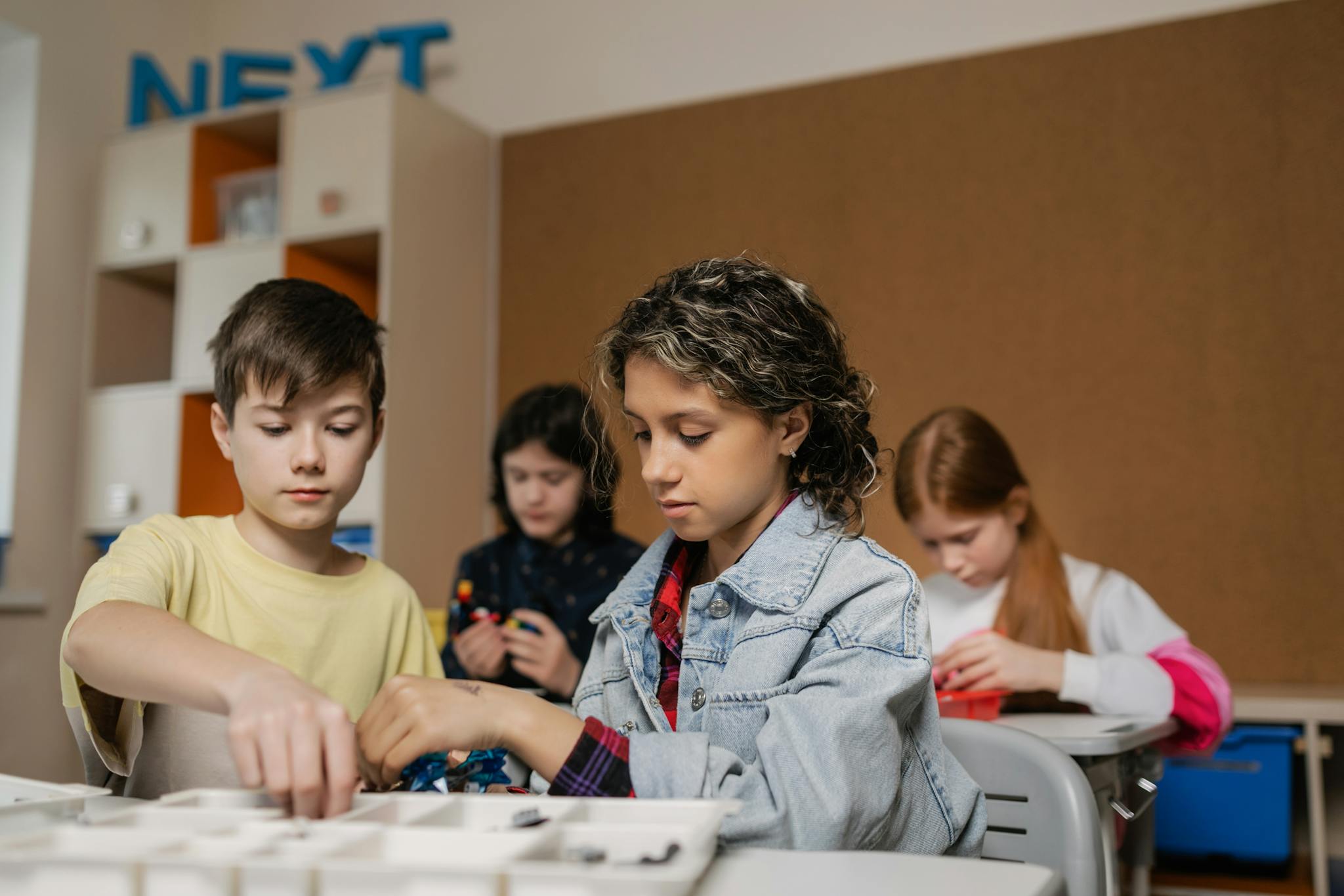 Children collaborating on robotics project in a classroom setting, fostering technology learning.