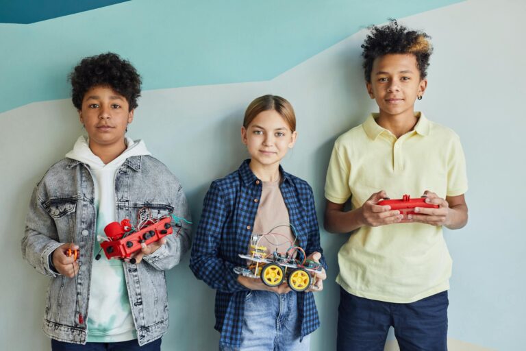 Three children holding robotic projects, showcasing diversity and teamwork.